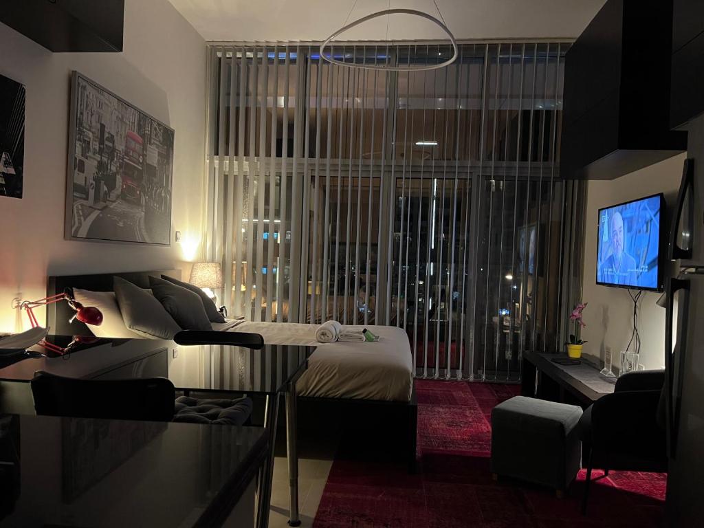 迪拜Super Studio in Dubai的一间卧室配有一张床、一台电视和一张沙发