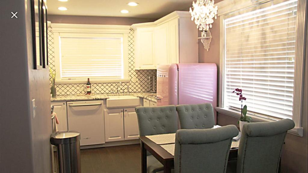 白鱼镇The Pink Fridge的厨房配有桌椅和冰箱。