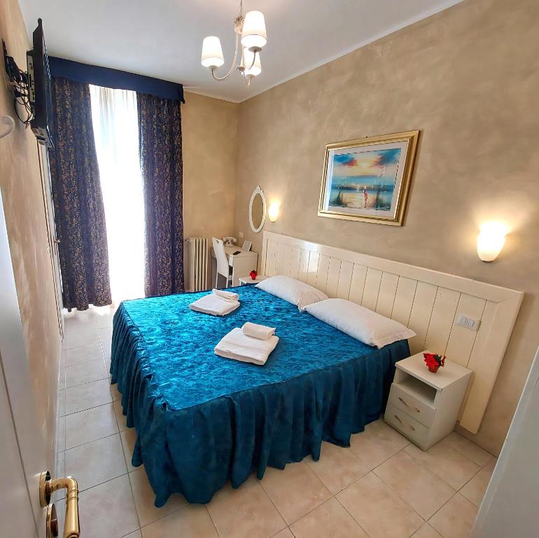 米兰Hotel Aurelia Milano Centrale的一间卧室配有蓝色的床和毛巾