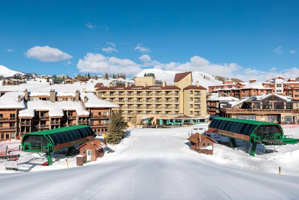 Mount Crested Butte艾勒维申温泉酒店的雪地中的度假胜地,有雪覆盖的建筑