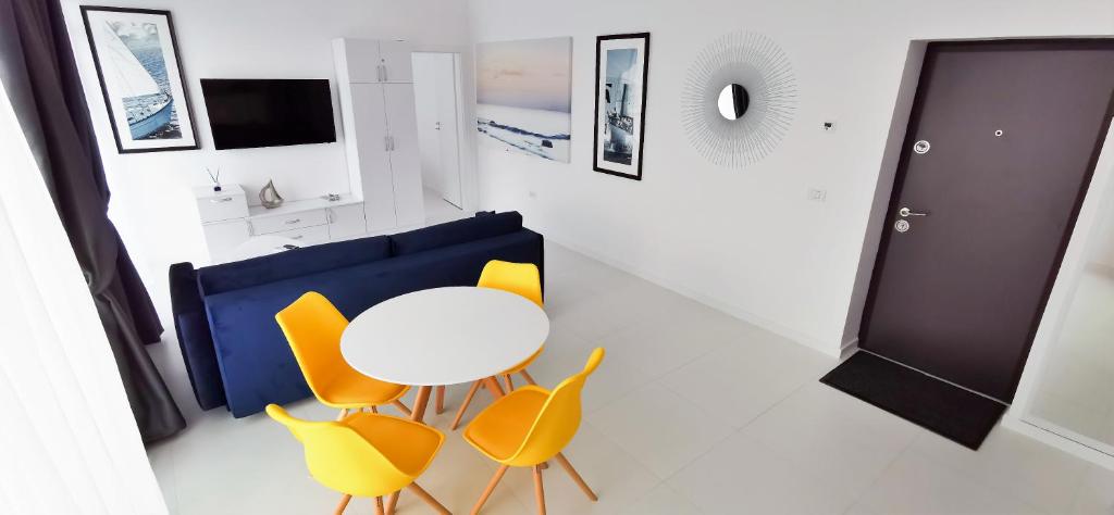 尼普顿OXYGEN NEPTUN BY BOUTIQUE C5的一间设有白色桌子和黄色椅子的客房