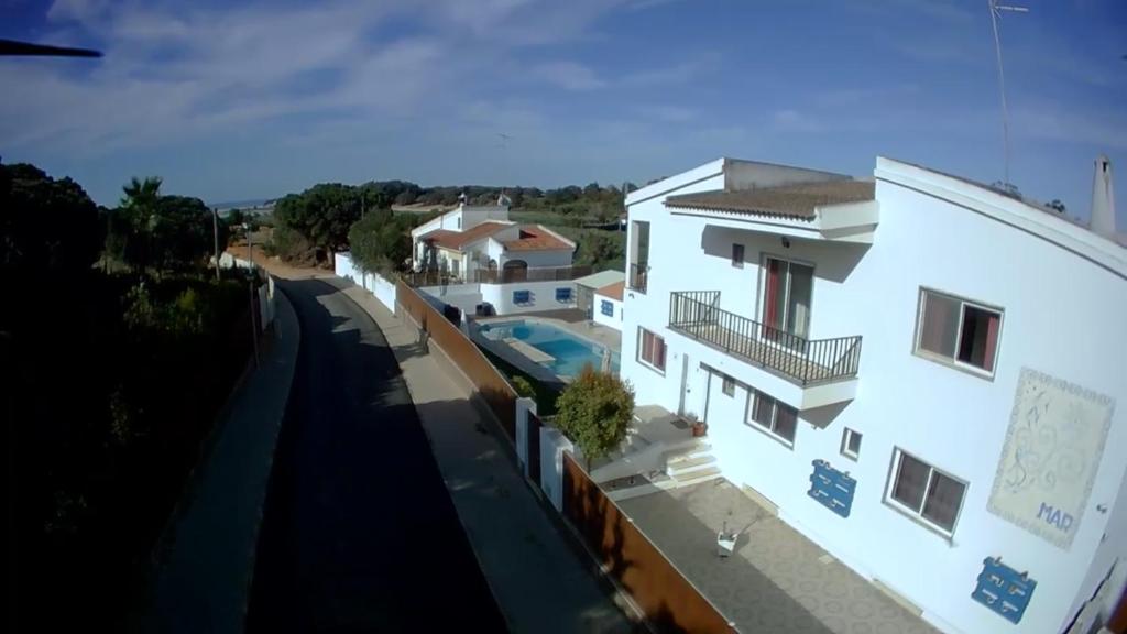 奎特里拉Hospedaria do Almargem的享有白色房屋的正面景致,设有游泳池