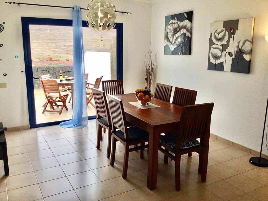 普拉亚布兰卡Villa Pura Vida的一间带木桌和椅子的用餐室
