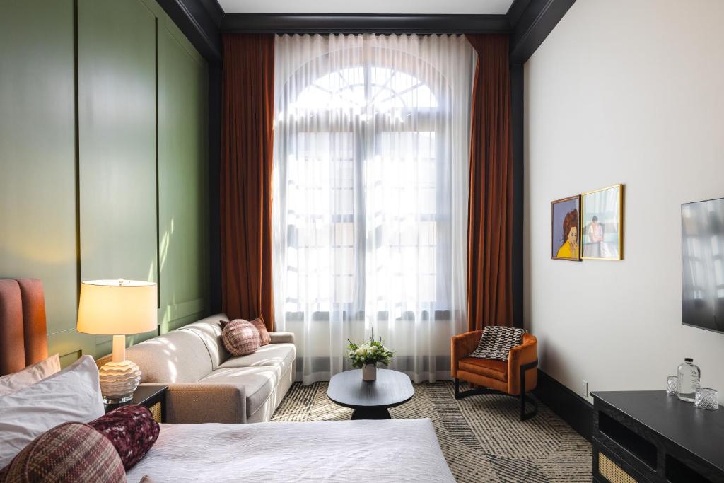 朴茨茅斯Hotel Thaxter的一间卧室配有一张床、一张沙发和一个窗口