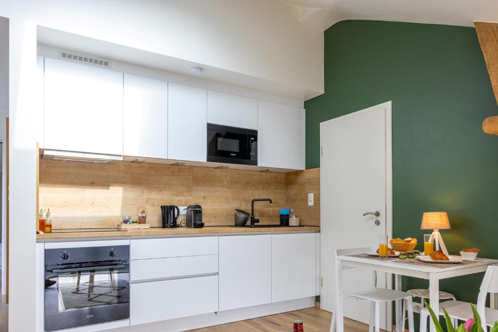 讷沙托Gîte Le Haut des Vannes的厨房配有白色橱柜和绿色墙壁