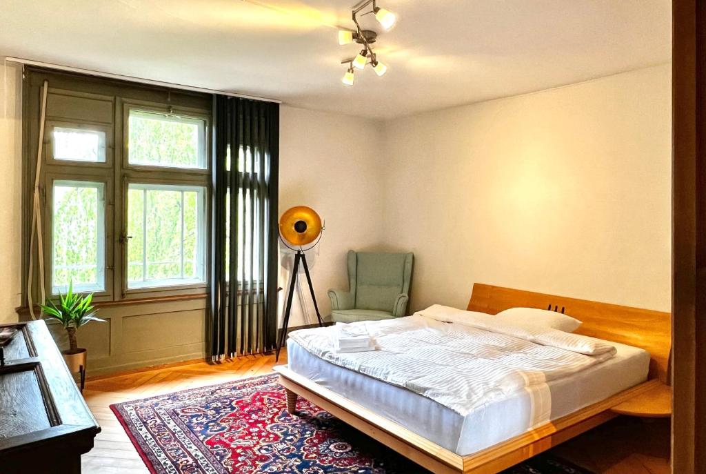 圣加仑Villa Bergruh的卧室配有床、椅子和窗户。