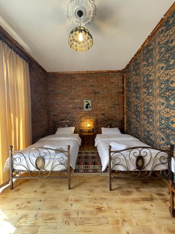 马尔特维利Odo’s Guest House的一间卧室配有两张床和吊灯。