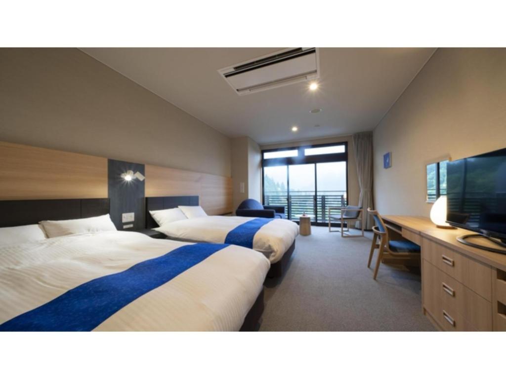 郡上市Hotel Sekisuien - Vacation STAY 44681v的酒店客房设有两张床和一台平面电视。