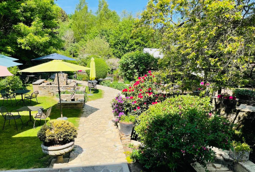 弗洛朗维尔Hostellerie Sainte-Cécile的花园设有桌椅和鲜花