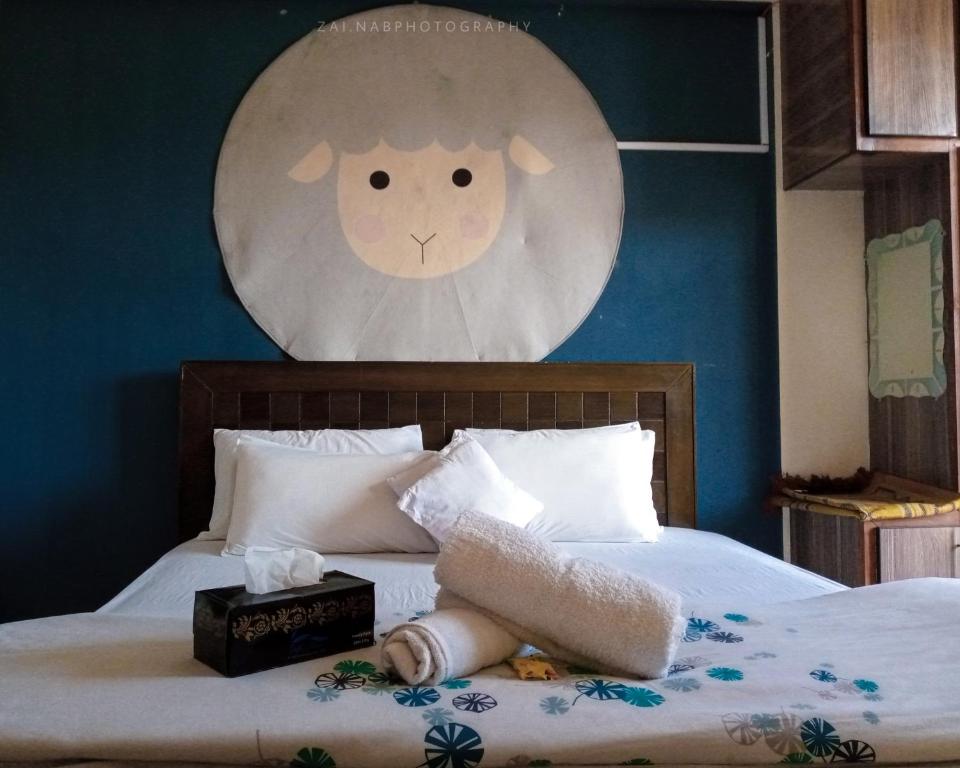 阿伯塔巴德Republika by Summit Resorts的卧室配有一张挂在墙上的带时钟的床