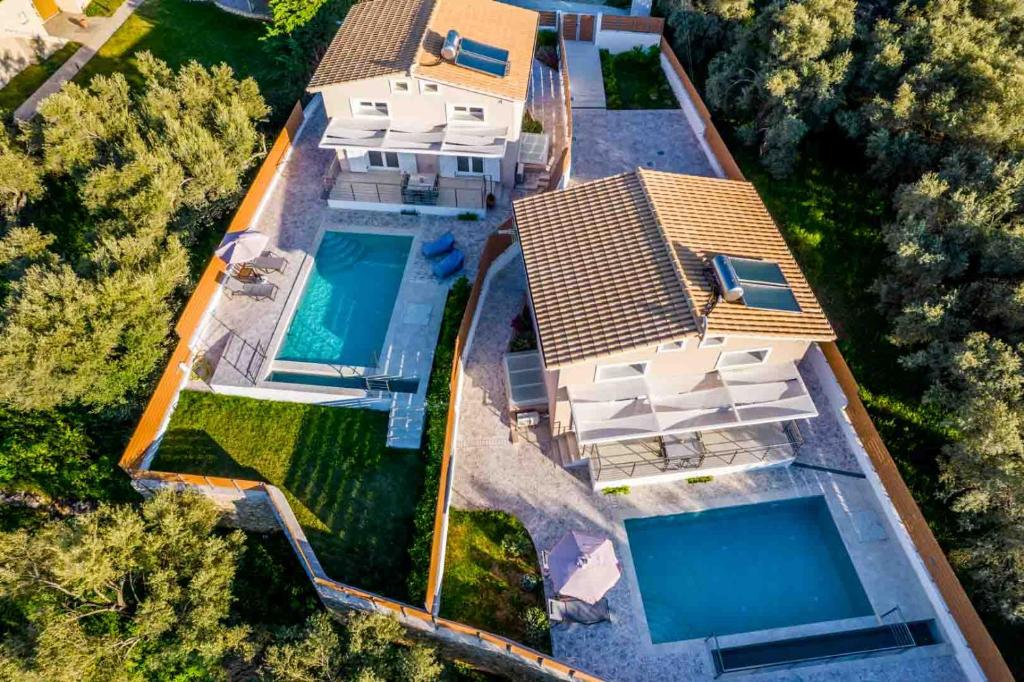 苏卡雷斯Elianthos Luxury Villas的享有带2个游泳池的别墅的顶部景致