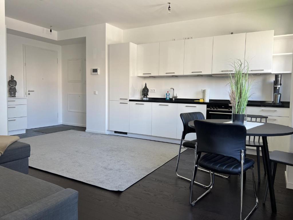 柏林Luxury Waterfront Apartment的厨房配有白色橱柜和桌椅