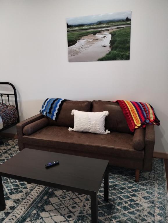 荷马Leisure Suite - Homer Seaplane Base的客厅配有一张棕色沙发,配有一张桌子