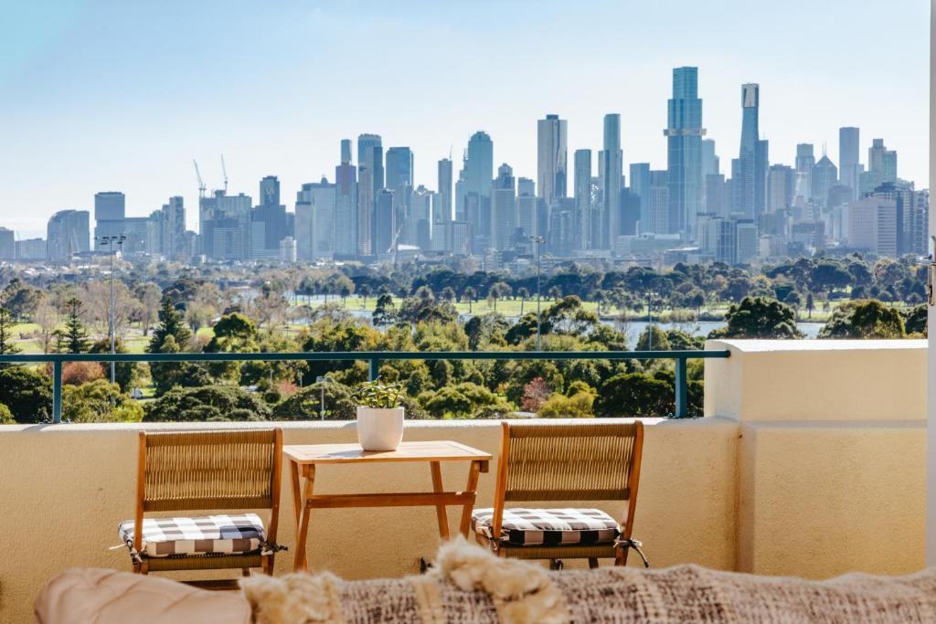 墨尔本Spectacular views over Albert Park的阳台配有桌椅,享有城市天际线