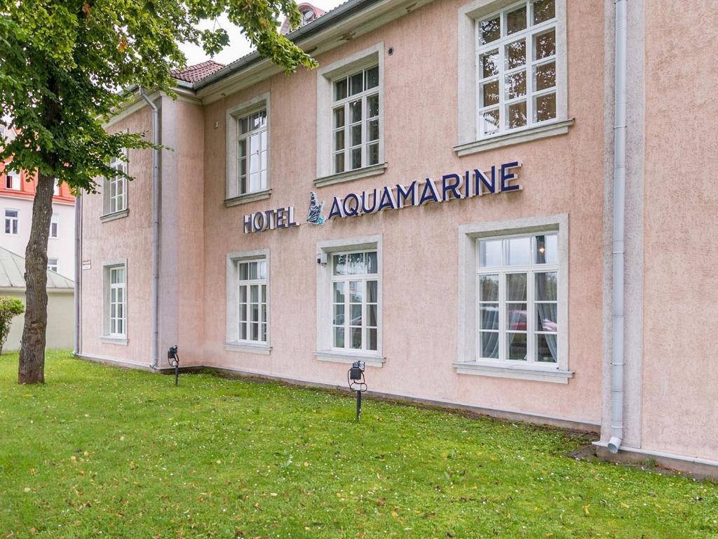 塔林Aquamarine Hotel - Lauluväljak的一座粉红色的建筑,上面标有读过雪崩酒店