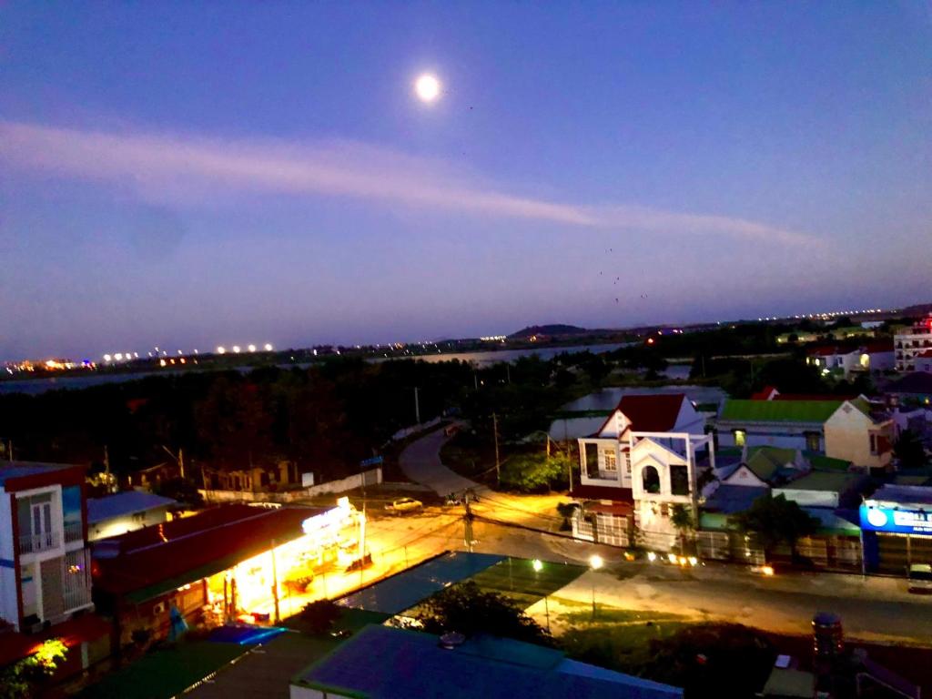 Xóm Mỹ CaThành Kiên Hotel的夜晚小镇与月亮的景色