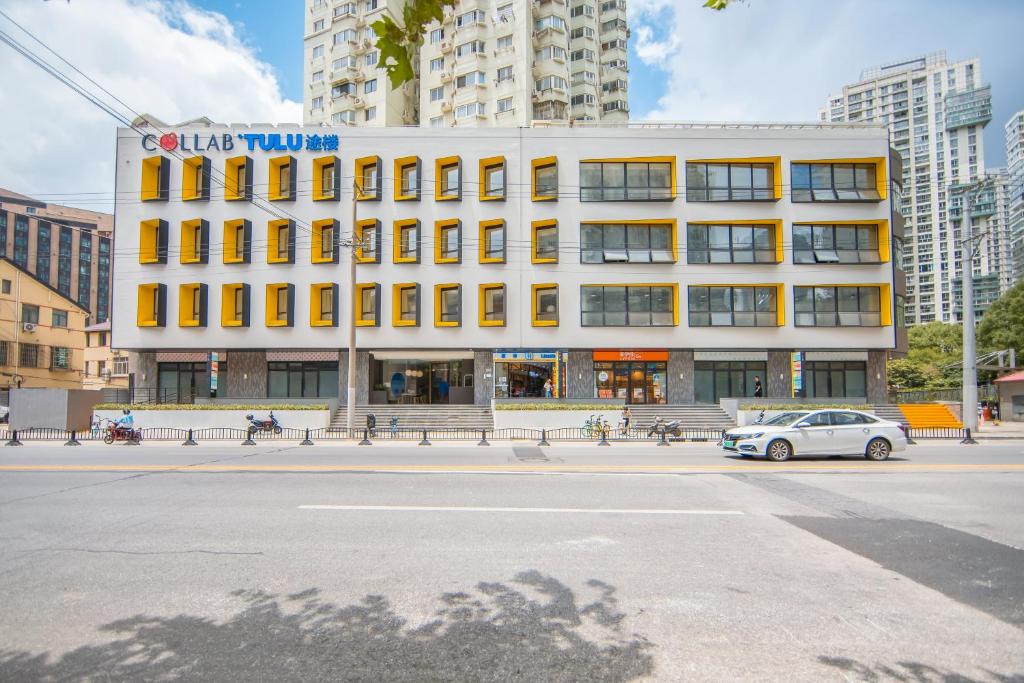 上海TULU途楼公寓(上海斜土路店)的停在大楼前的白色汽车