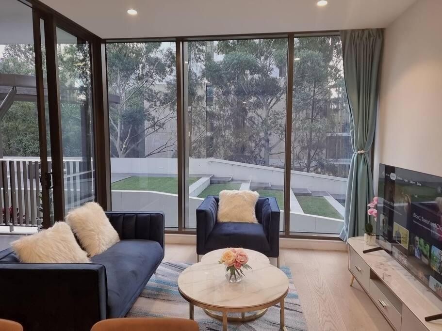 悉尼Sapphire Royale Suite in Macquarie Park的客厅配有两张沙发和一台电视机