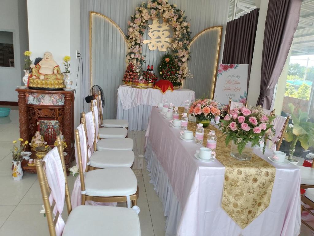 Ấp Sung XuânHomestay Hoài Tâm Phan Thiết的一排桌椅,上面有鲜花