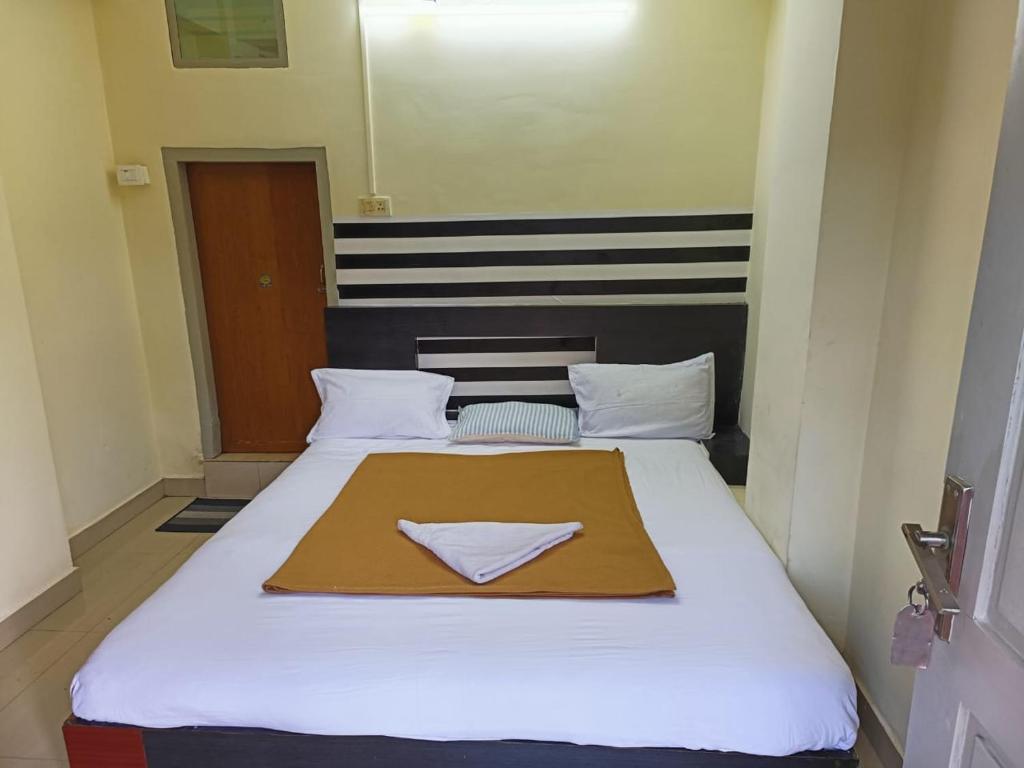 奎隆Hotel Orginal Residency的卧室配有一张白色大床和餐巾纸