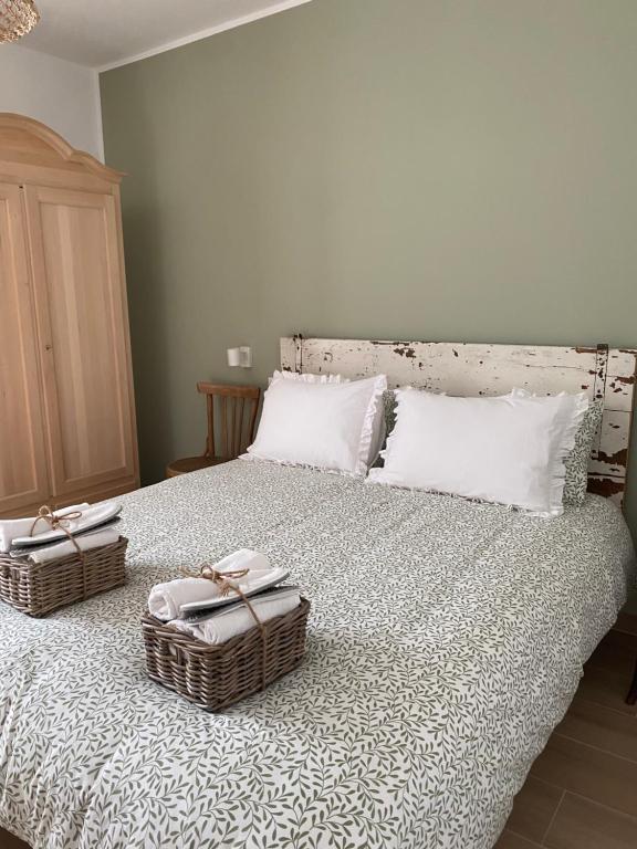 戈里齐亚B&B Antico Fienile的一间卧室配有一张带两个篮子的床
