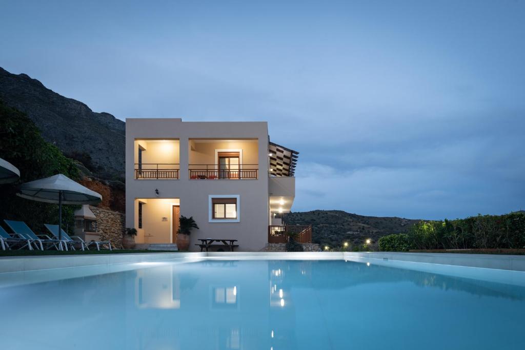 特里欧皮特拉Triopetra Luxury Villas Panagia的夜间带游泳池的别墅