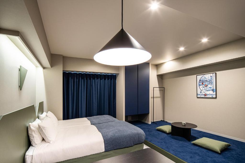 东京Section L Kuramae - Asakusa的卧室配有白色的床和蓝色地毯。