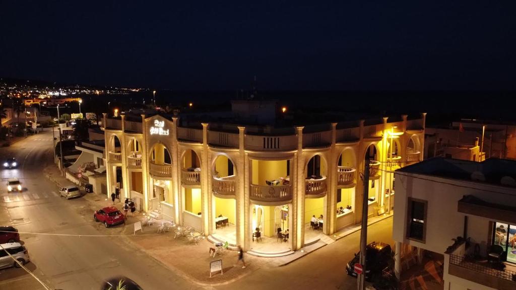 佩斯科勒海滨Hotel Salento Gold Beach的街上的一座大建筑,晚上有灯
