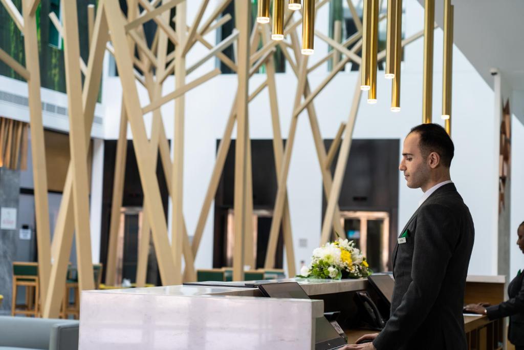 迪拜Al Khoory Courtyard Hotel的站在桌子上的穿着西服的人