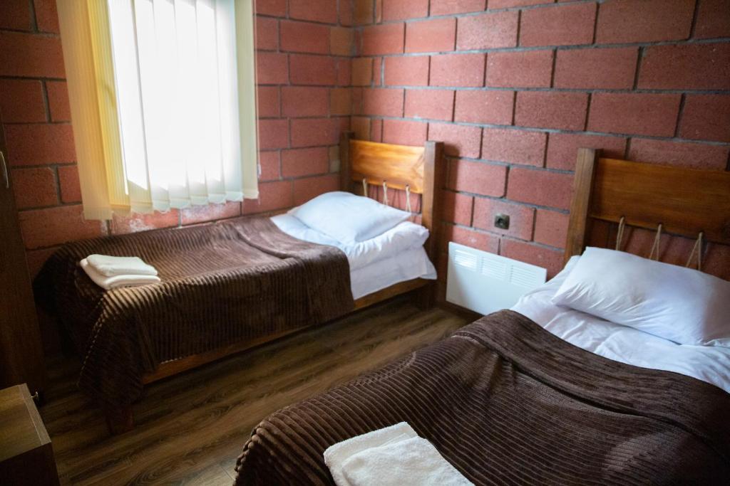 AghavnadzorNoravank L-and-L的砖墙客房的两张床