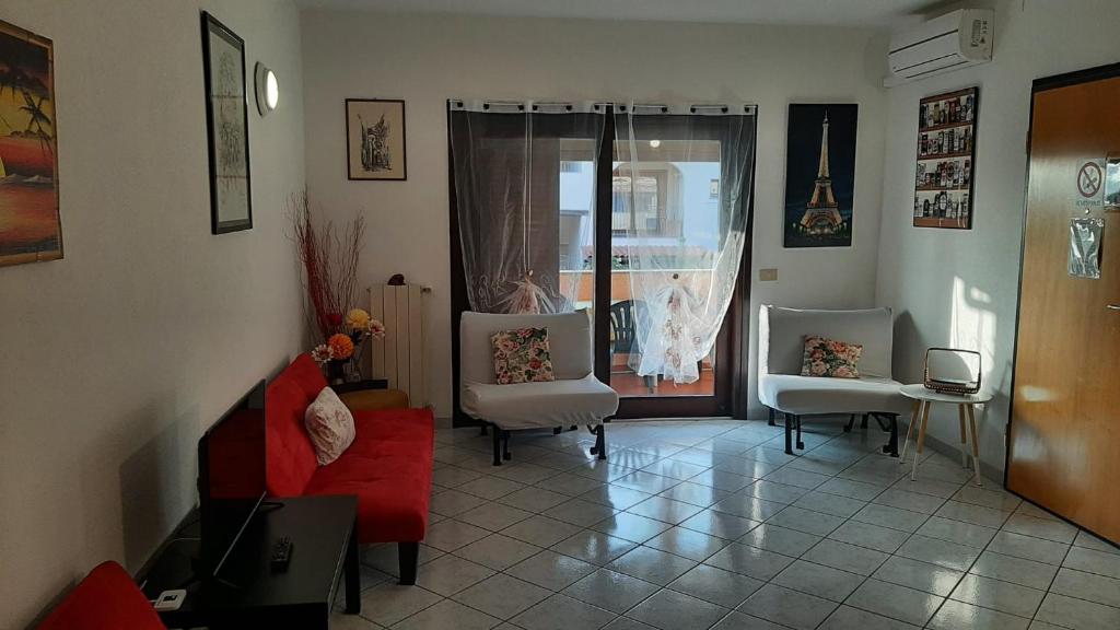 奥尔比亚PRESSI AEROPORTO COSTA SMERALDA的客厅配有红色的沙发和两把椅子