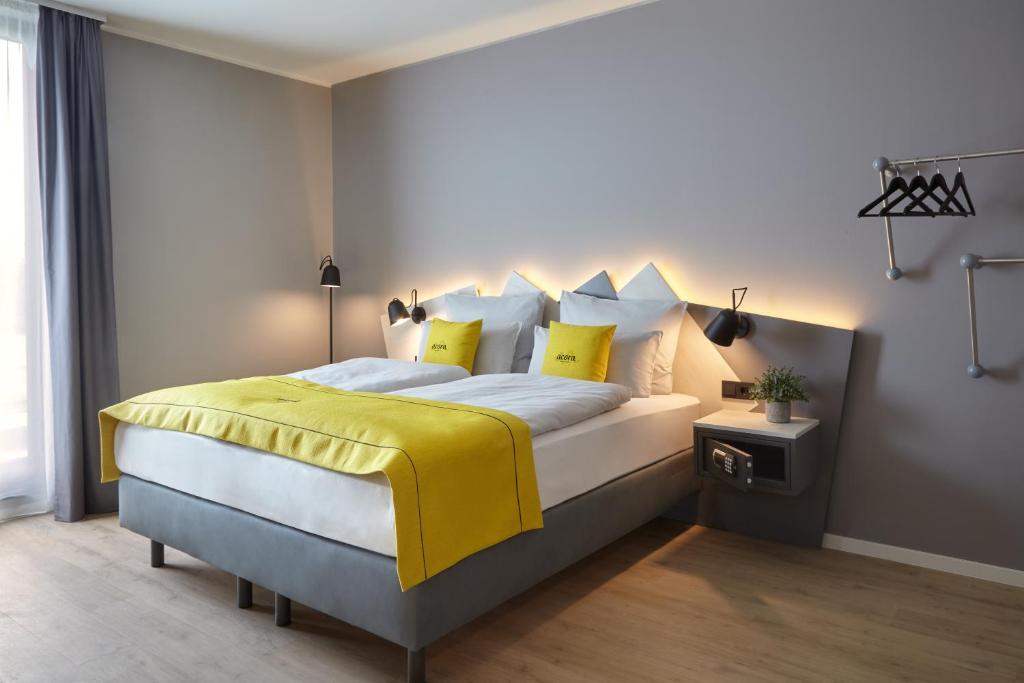 杜塞尔多夫acora Düsseldorf Airport Living the City的卧室配有一张带黄色床单和枕头的大床。