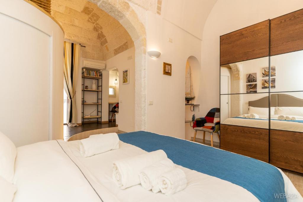 滨海波利尼亚诺Suite Novecento的一间卧室配有带毛巾的床