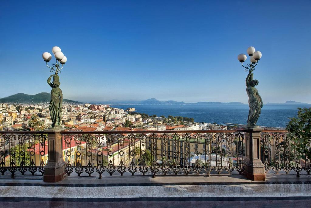那不勒斯帕克斯大酒店的阳台享有城市美景,设有两座雕像