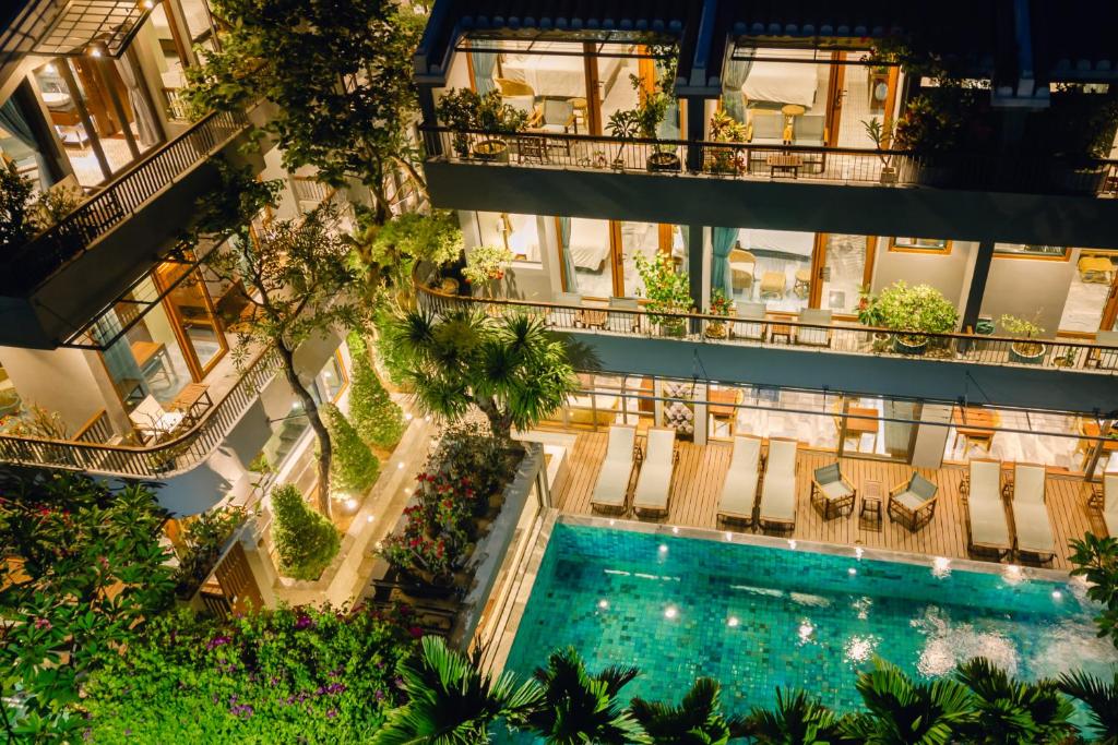 会安CHiEM HoiAn - The Beachside Boutique Hotel & Villa的享有带游泳池的公寓大楼的顶部景致