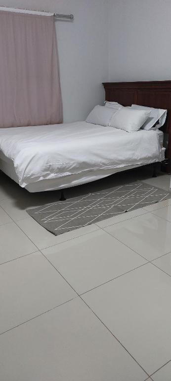 温特和克Special Inn Bed and Breakfast的卧室内的一张床位,铺有瓷砖地板