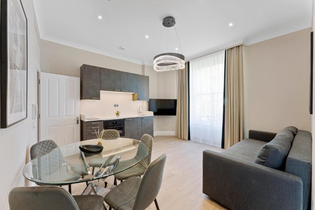 伦敦Cleveland Residences Paddington的带玻璃桌和椅子的客厅