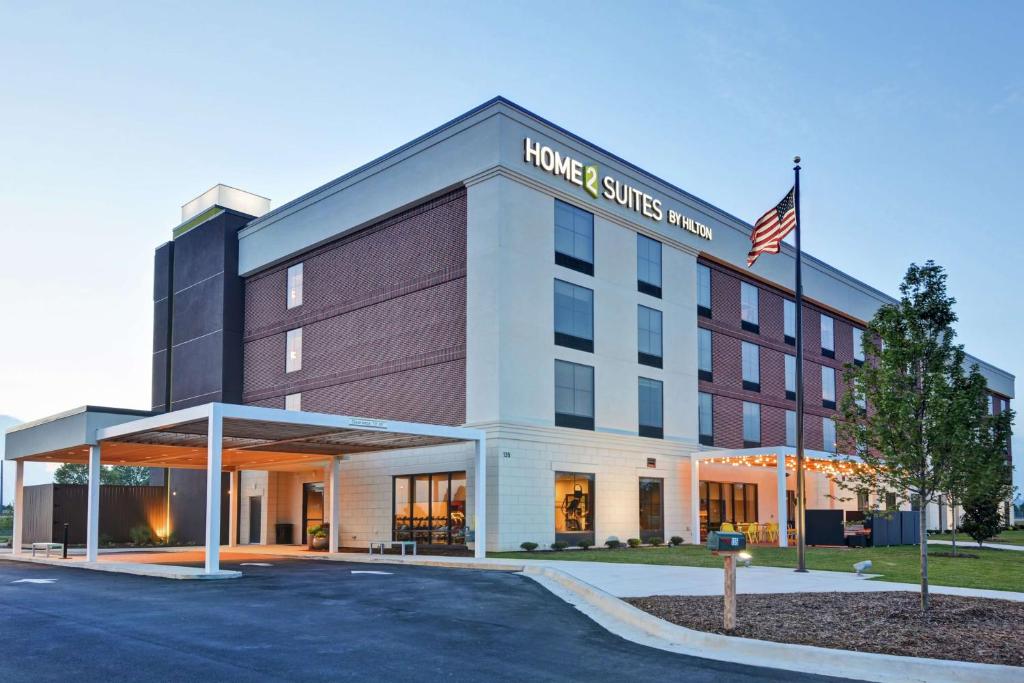 麦迪逊Home2 Suites By Hilton Madison Huntsville Airport的前面有美国国旗的建筑