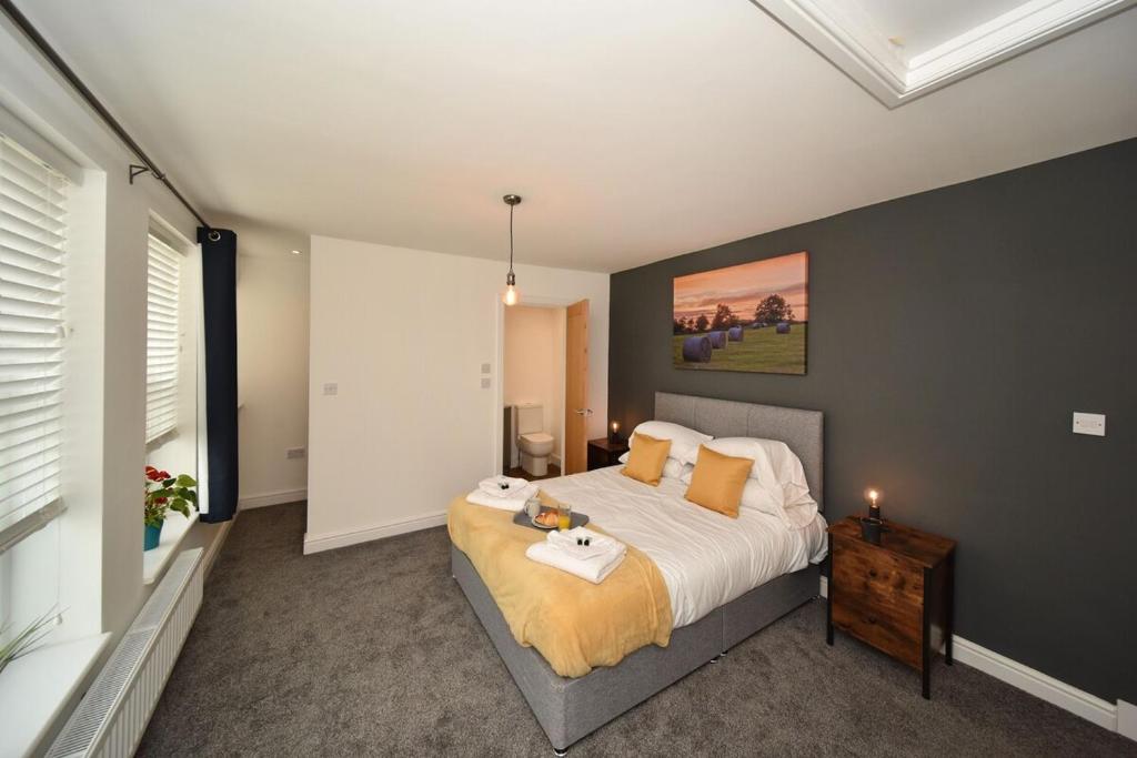 麦克尔斯菲尔德Pinfold Suite - Chester Road Apartments By的一间卧室配有一张床和一张桌子
