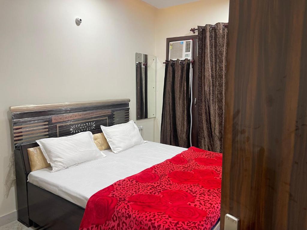 阿姆利则Homestay Comforts 500m from Amritsar Airport的一间卧室配有一张带红色毯子的床