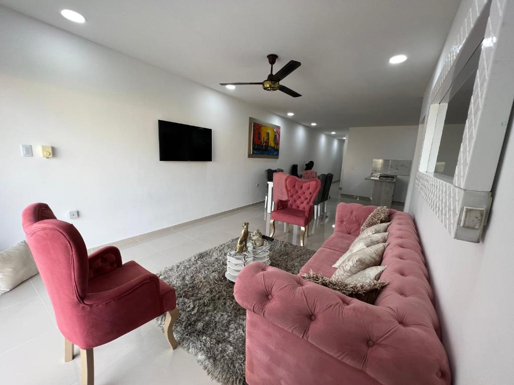 蒙特里亚Hermoso apartamento central的客厅配有粉红色的沙发和两把椅子