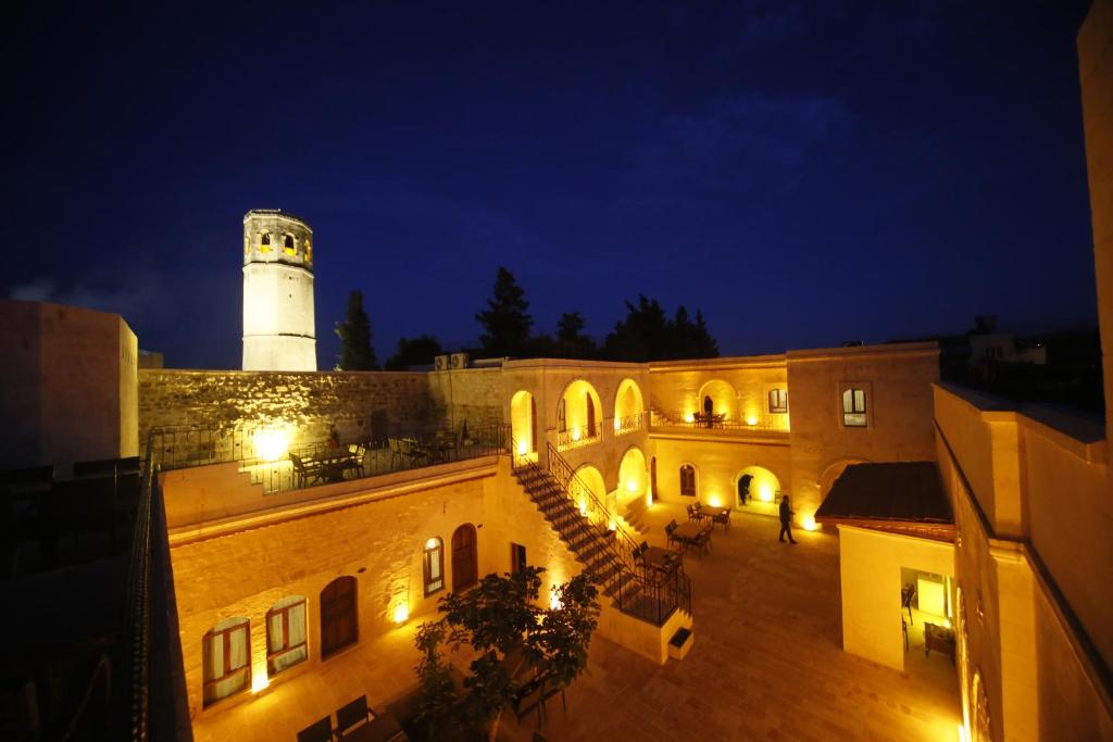 尚勒乌尔法PALMYRA BOUTIQUE HOTEL的一座建筑,上面有一个灯塔,晚上