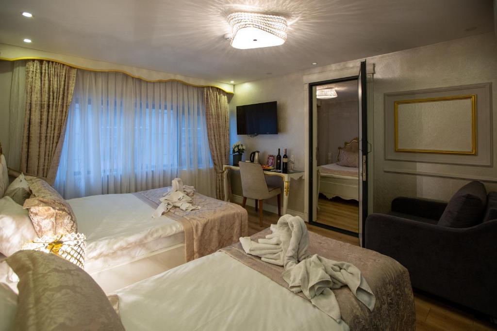 伊斯坦布尔Sirkeci Ersu Hotel & SPA的酒店客房,配有两张床和椅子