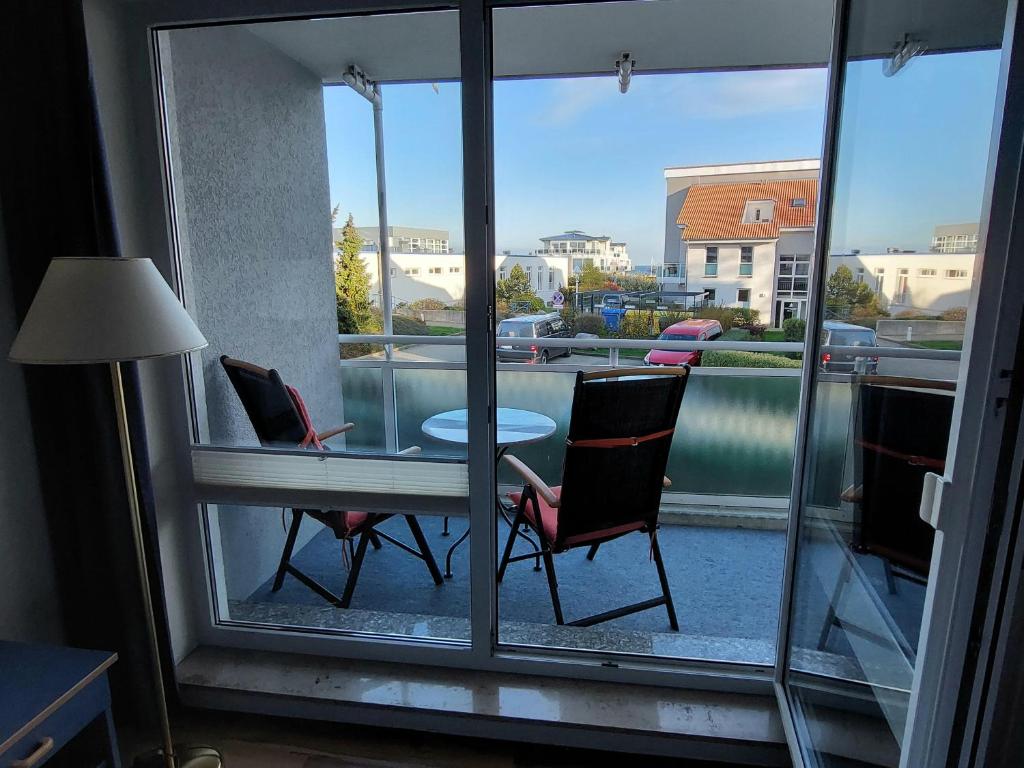 奥斯赛拜-屈隆斯博恩Yachthafenresidenz-Wohnung-8205-853的客房享有带桌椅的阳台的景致。