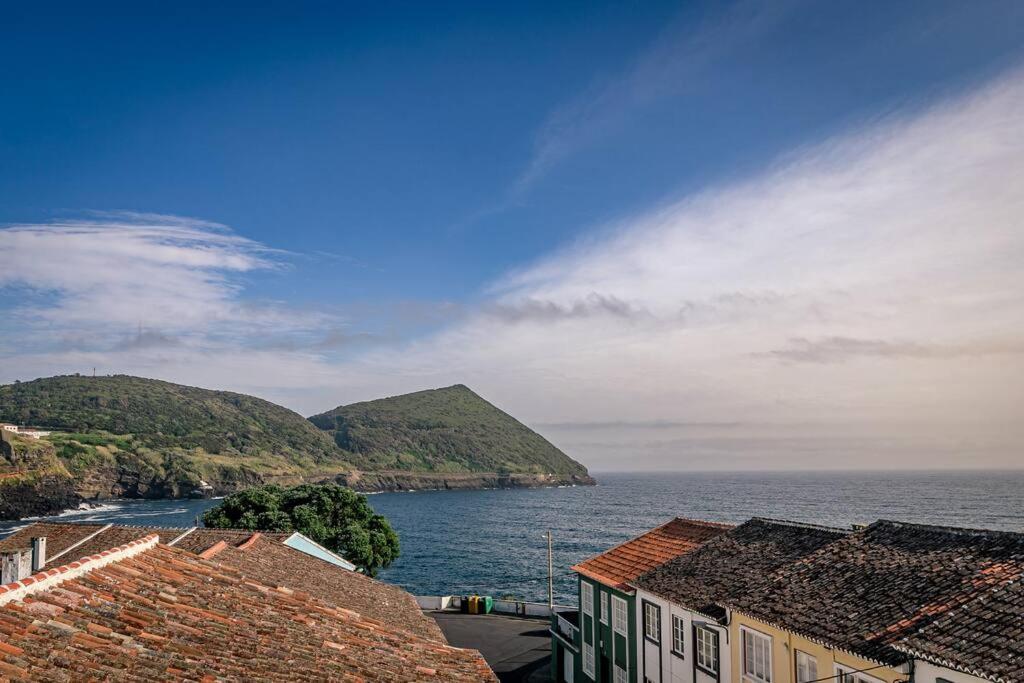 英雄港Casa Silveira Mar的享有水体、房屋和山脉的景色