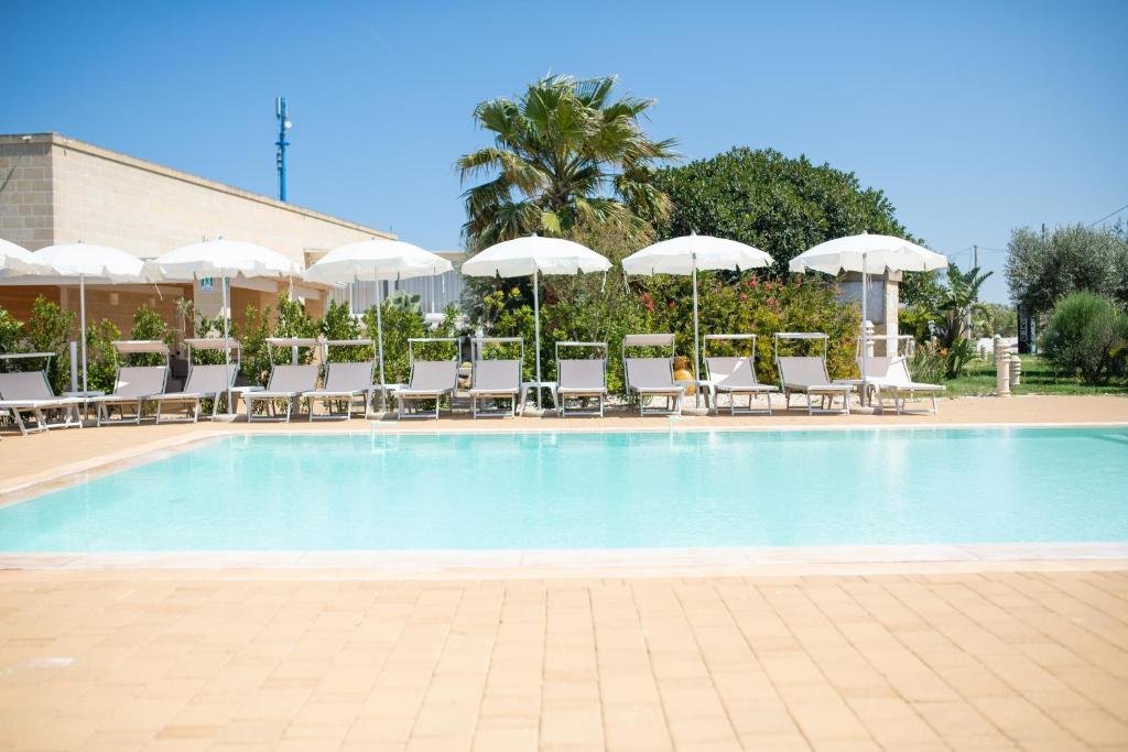托雷桑塔萨宾娜瑞福斯酒店的一个带椅子和遮阳伞的大型游泳池