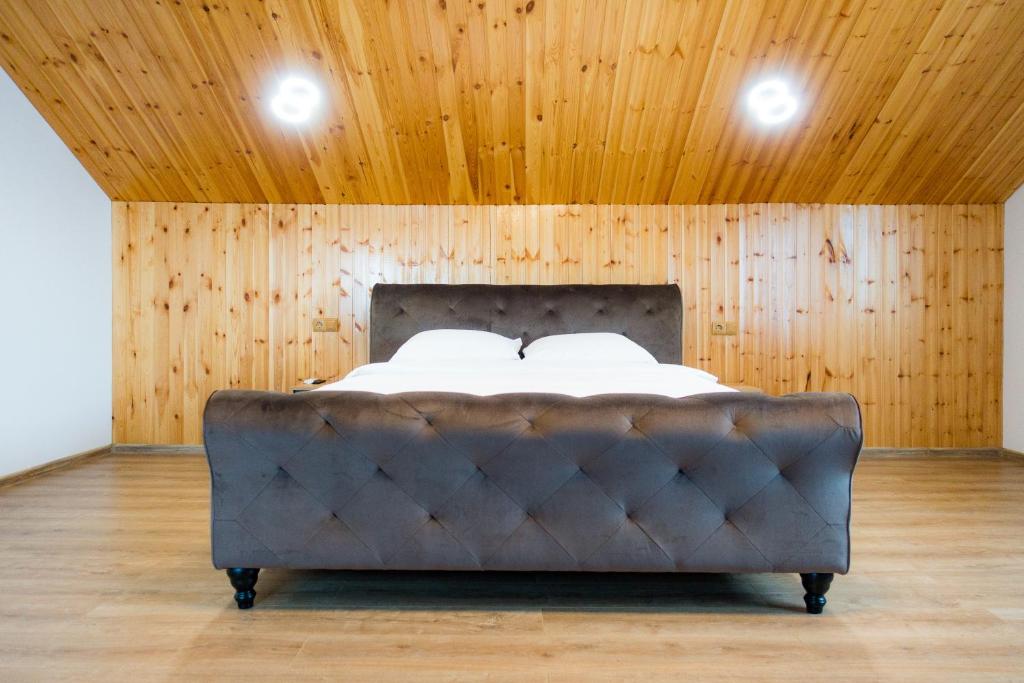 锡比乌EDA ROOMS的木天花板的客房内的一张床位
