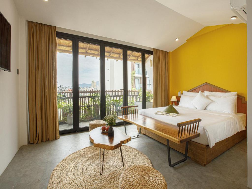 岘港TA Danang Boutique Hotel的一间卧室设有一张床和一个大窗户