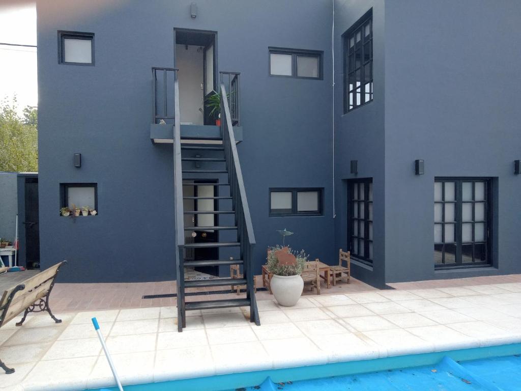 坦迪尔Apart Lo de Jose的蓝色的建筑,带有梯子,靠近游泳池