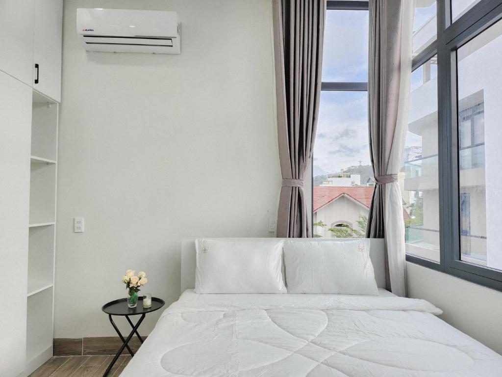 头顿An Home - Phòng đơn ngay bãi sau Vũng Tàu的卧室配有白色的床和窗户。
